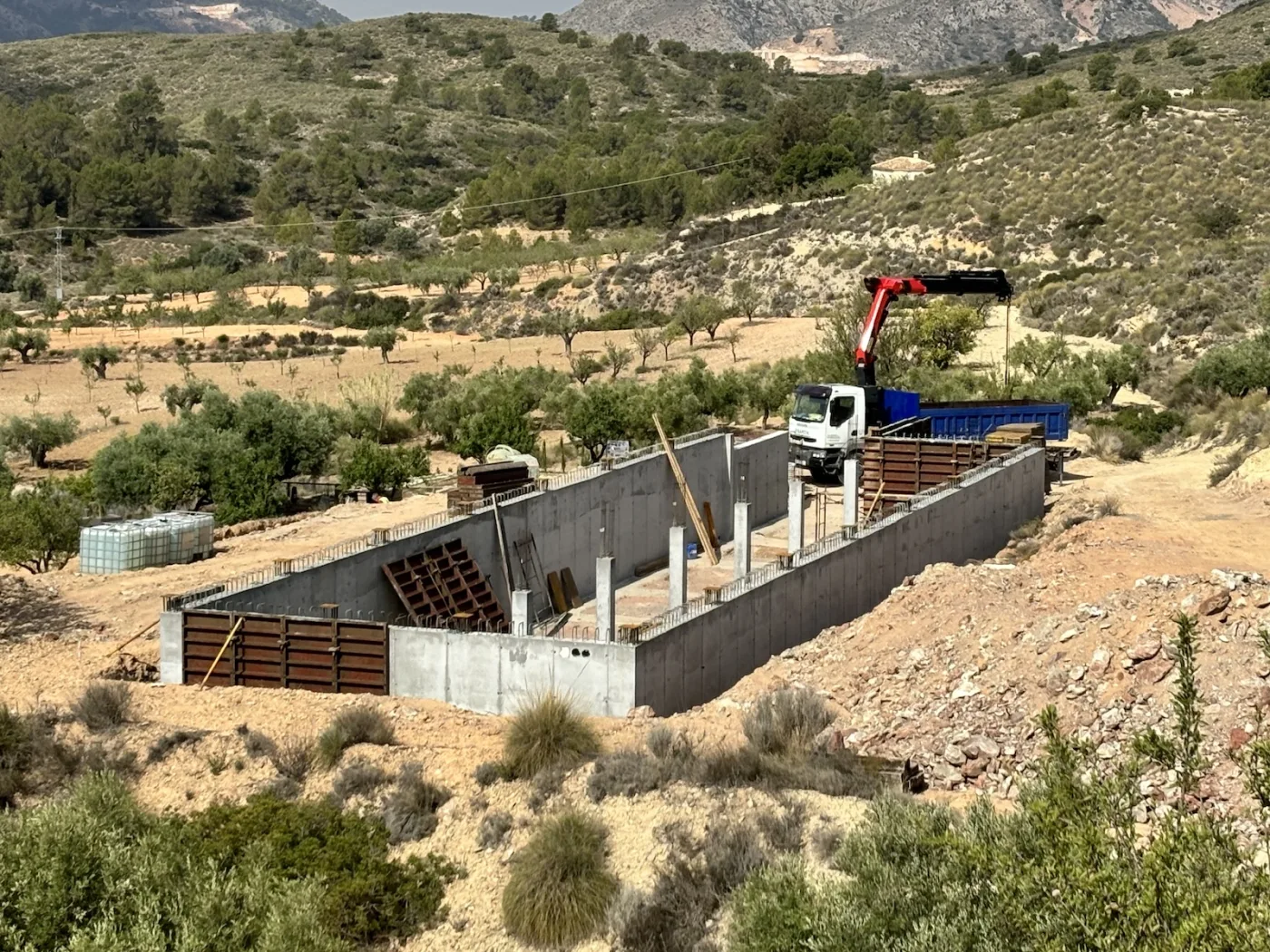 De kraan bij de betonnen kelderwanden